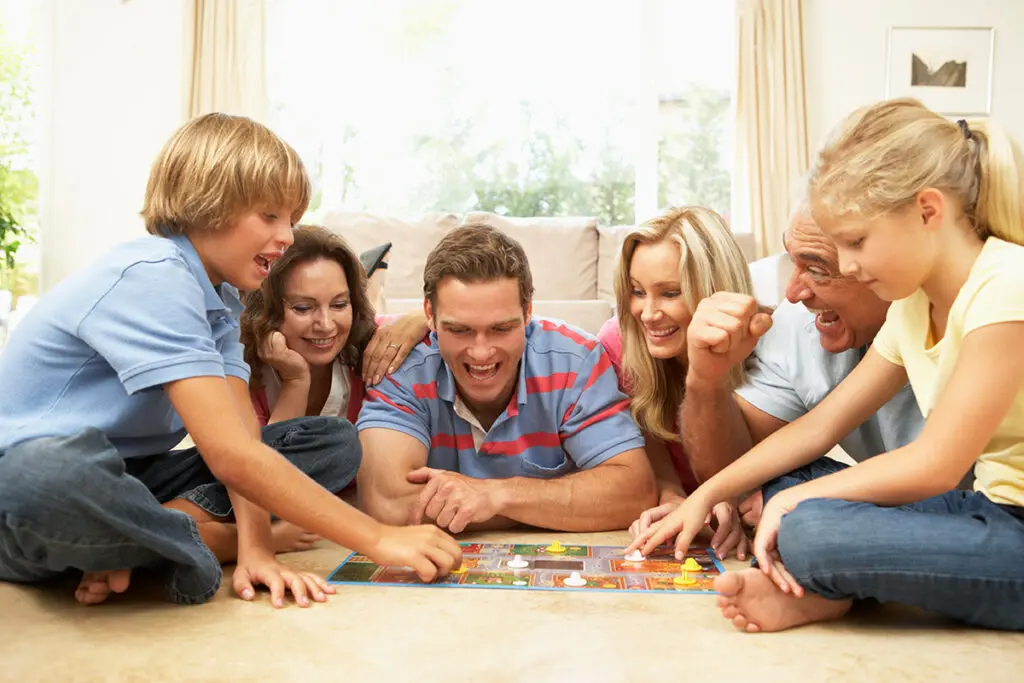 Family Playing Board Game At Home With Grandparents Watching