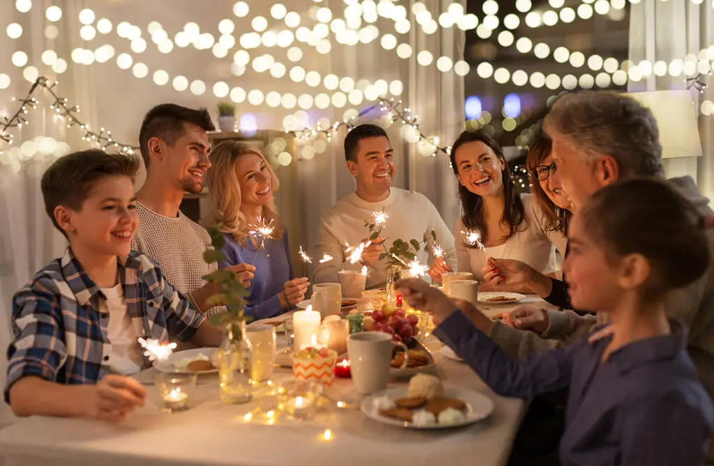 family with sparklers having dinner party at home