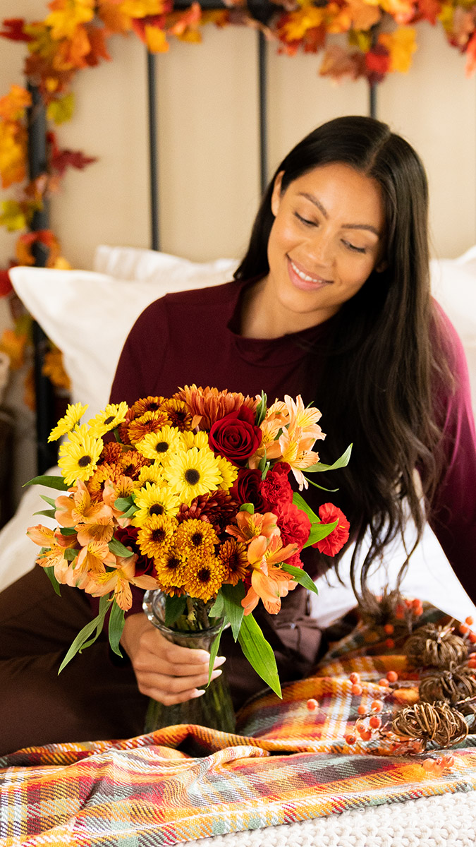 birthday blues woman admiring flowers on bed