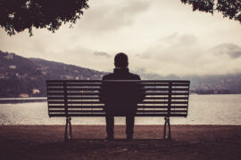 Como, Italy February , : A lonely man sitting on the ben