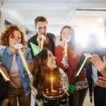 Group of young people celebrating a birthday in the office