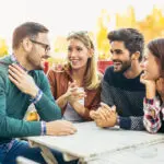 Group of four friends having fun a coffee together. Two women an
