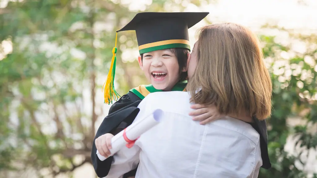 Asian mother embracing her son on graduation day